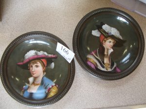 Lot 166 - Two painted Berlin plaques of ladies wearing hats - Sold for £80