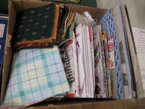 Lot 215 - Box of cross stitch charts and fabric squares - Sold for £25